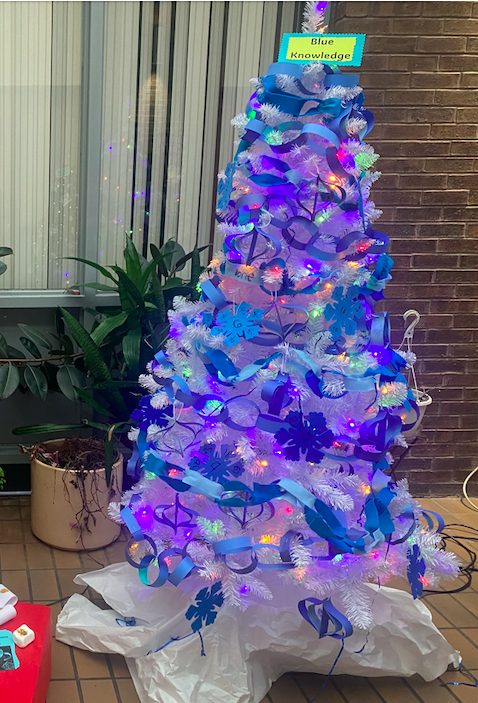 Christmas tree decorated with blue snowflakes and blue paper garland 
